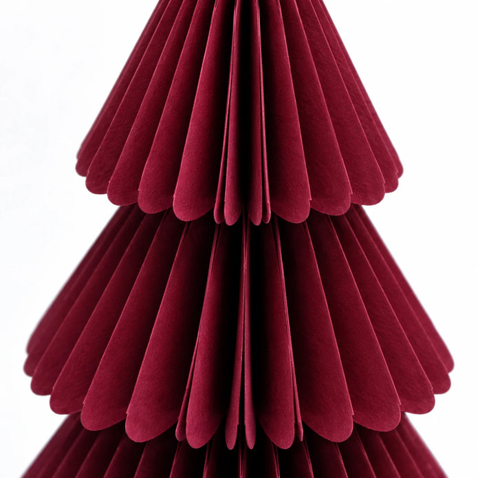 Close-up of burgundy paper folds and scalloped tier edges.