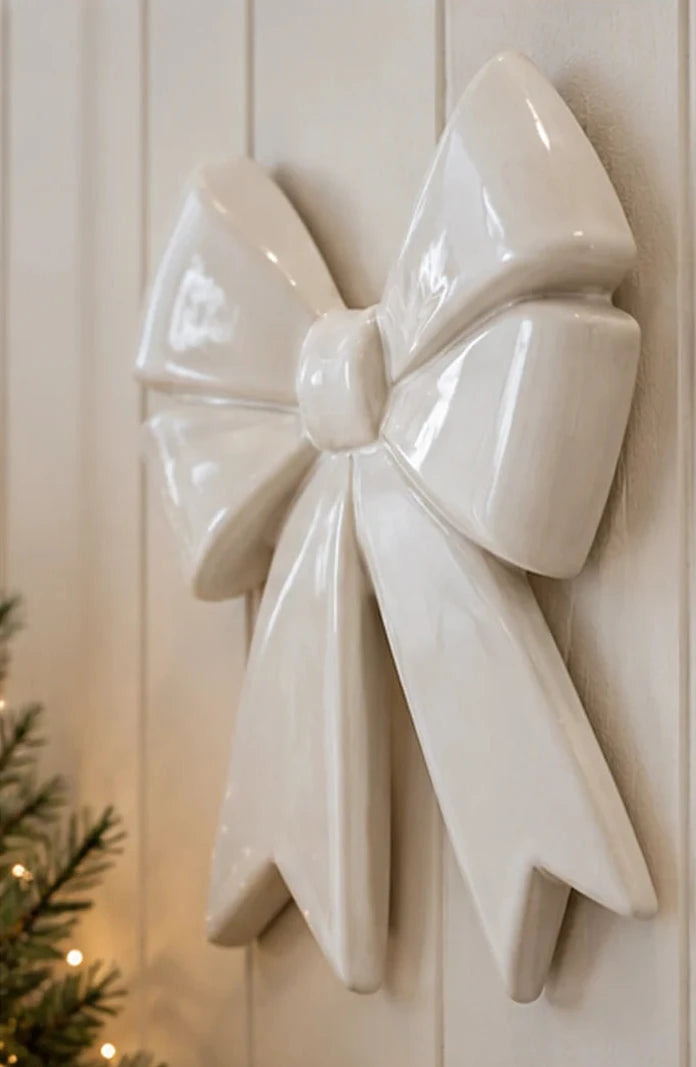 Side-angle view of large white ceramic bow wall decoration in a neutral country home