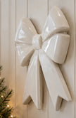 Side-angle view of large white ceramic bow wall decoration in a neutral country home
