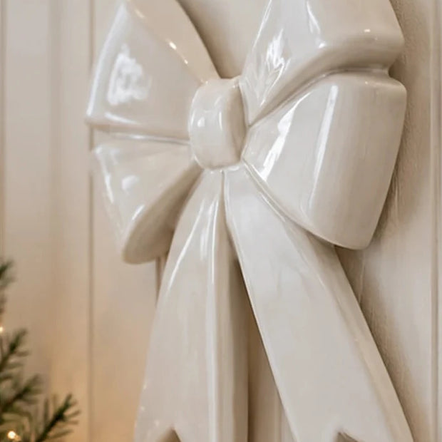 Side-angle view of large white ceramic bow wall decoration in a neutral country home