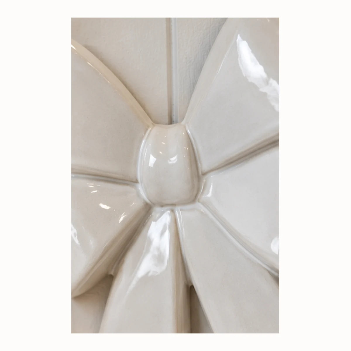 Close-up of the smooth glazed ceramic knot and folded loops of the white double bow
