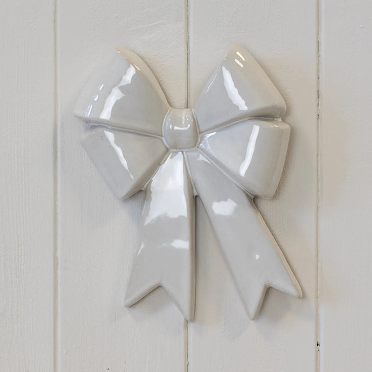 Large white ceramic double bow original product full front view with sculpted loops and pointed ribbon tails