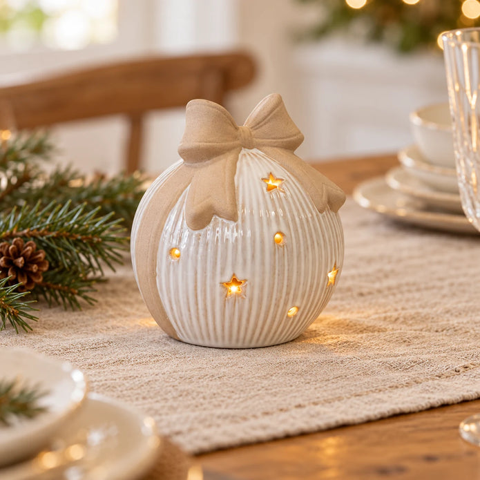Large ceramic LED bauble with bow topper on a linen Christmas table