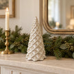 Ceramic pinecone Christmas tree styled on a cream mantel with festive greenery