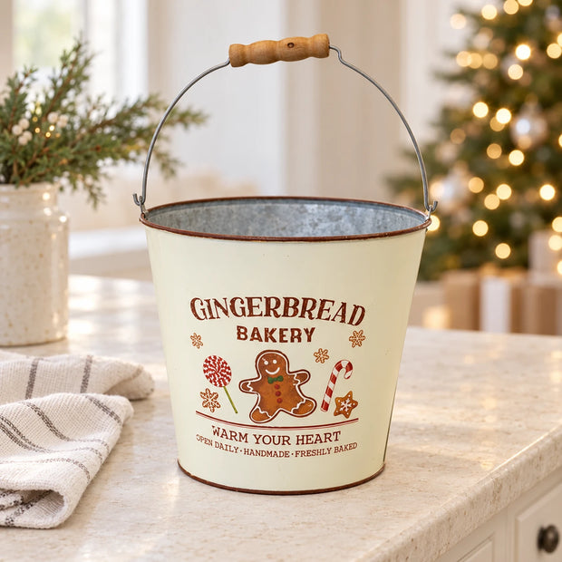 Cream gingerbread bakery bucket beside Christmas greenery and tree lights