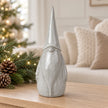 Large pale grey glazed ceramic gonk on an oak console with neutral Christmas greenery