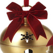 Close-up of gold Christmas bell with burgundy velvet bow and snowflake cut-out detail
