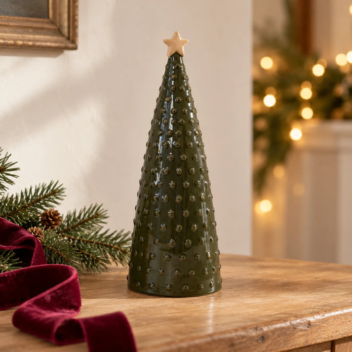 Large green pimpled ceramic Christmas tree with a tan star, styled on an oak console with fir and burgundy ribbon.