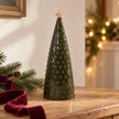 Large green pimpled ceramic Christmas tree with a tan star, styled on an oak console with fir and burgundy ribbon.