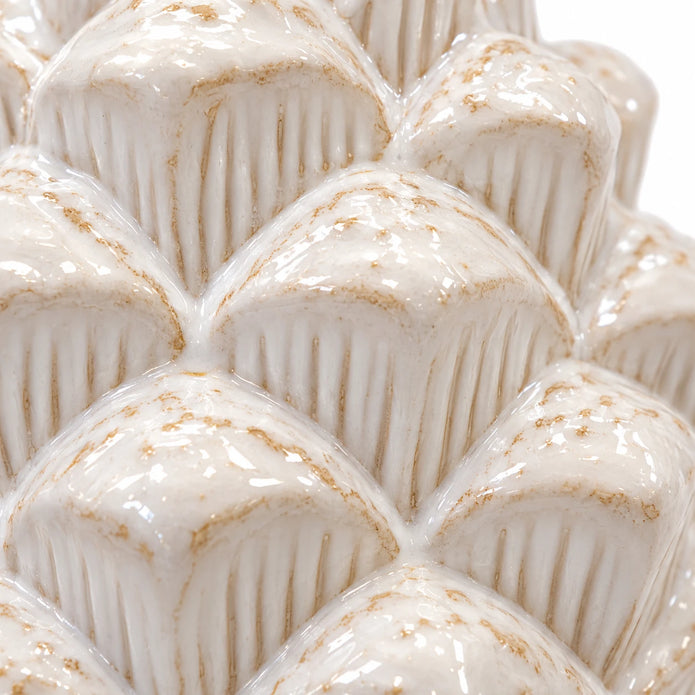 Close-up of overlapping ridged scales and ivory glaze on the ceramic pinecone