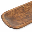 Close-up of the large rustic dough bowl’s rounded rim and hand-carved brown wood texture.