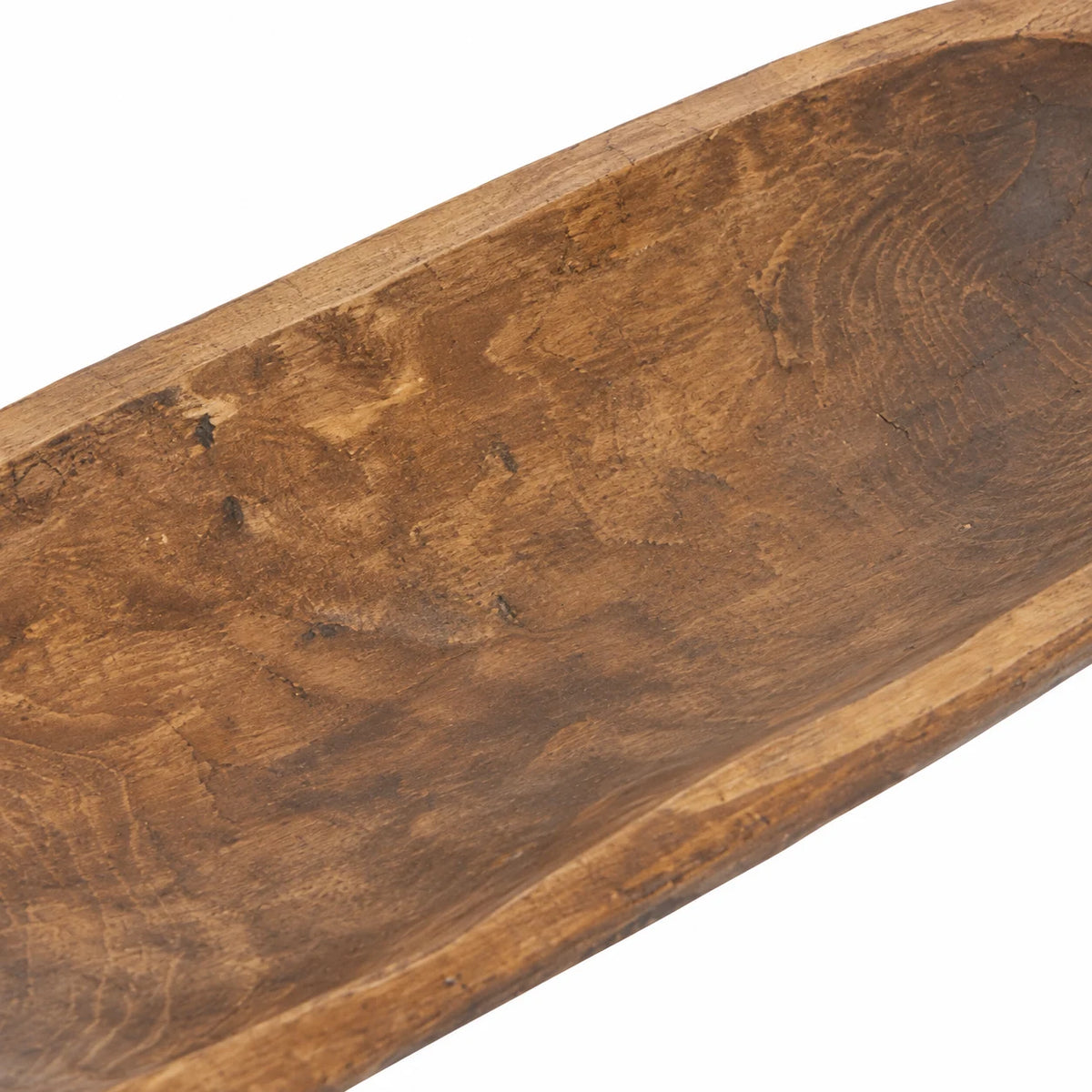 Close-up of the large wooden dough bowl’s inner basin, showing weathered grain and carving marks.