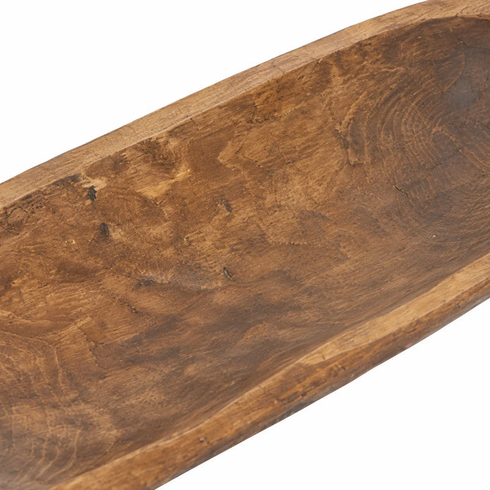 Close-up of the large wooden dough bowl’s inner basin, showing weathered grain and carving marks.