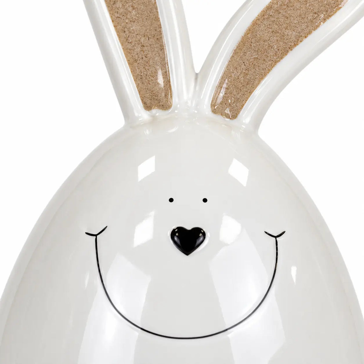 Close-up of the large white ceramic rabbit showing its black heart nose, fine smile and glossy glaze.