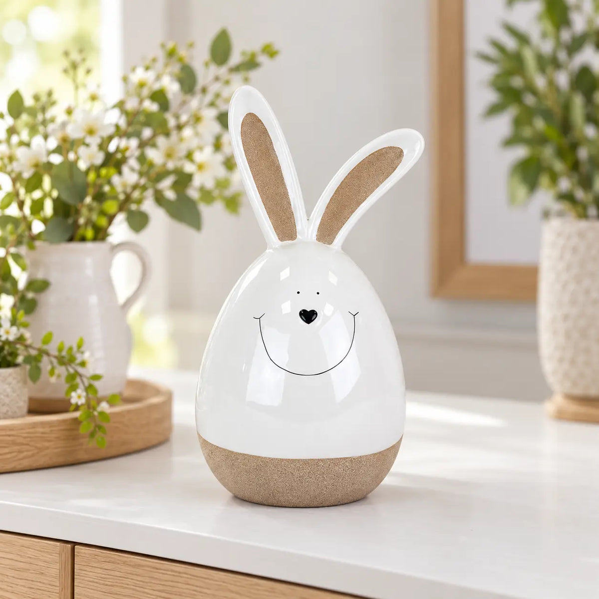 Large white ceramic rabbit on a white dining sideboard with spring greenery and pale oak accents.