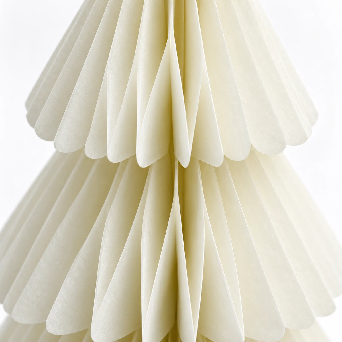 Close-up of winter white paper folds and scalloped tier edges.