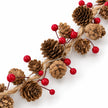 Close-up of natural pinecones, glossy red berries, jute cord and unlit LEDs on the garland.