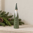 Light green and white ceramic Christmas gonk on a limestone mantel with pine foliage.