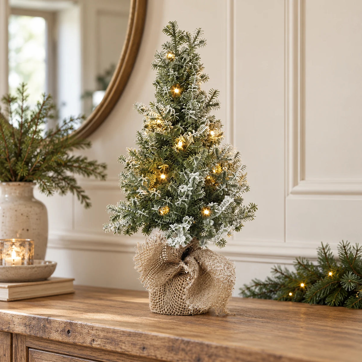 Small light-up frosted Christmas tree on an oak hallway console