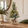Small light-up frosted Christmas tree on an oak hallway console