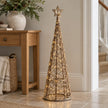 LED rattan Christmas tree glowing beside an oak hallway console.