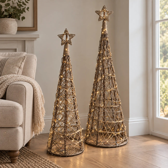 Two LED rattan Christmas trees styled together in a neutral living room; trees sold individually.
