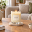 Heaven Scent Lime, Basil & Mandarin Medium Candle, lit in clear glass on a stone coaster in a living room