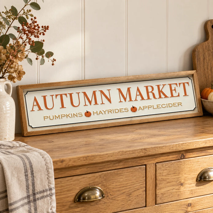 Long Autumn Market Pumpkin Sign on an oak sideboard with a ceramic vase.