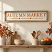 Long Autumn Market Pumpkin Sign hanging above a country kitchen shelf.