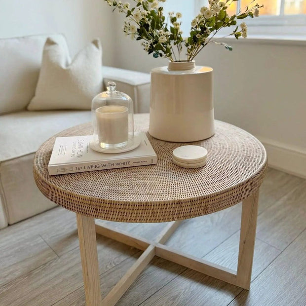 Lows rattan round coffee table with a natural woven surface and wooden legs, perfect for a stylish living room decor.