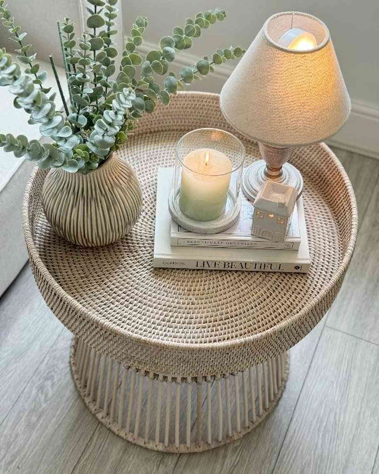 Lows rattan round side table with a natural woven surface and wooden legs, ideal for living room or bedroom decor.