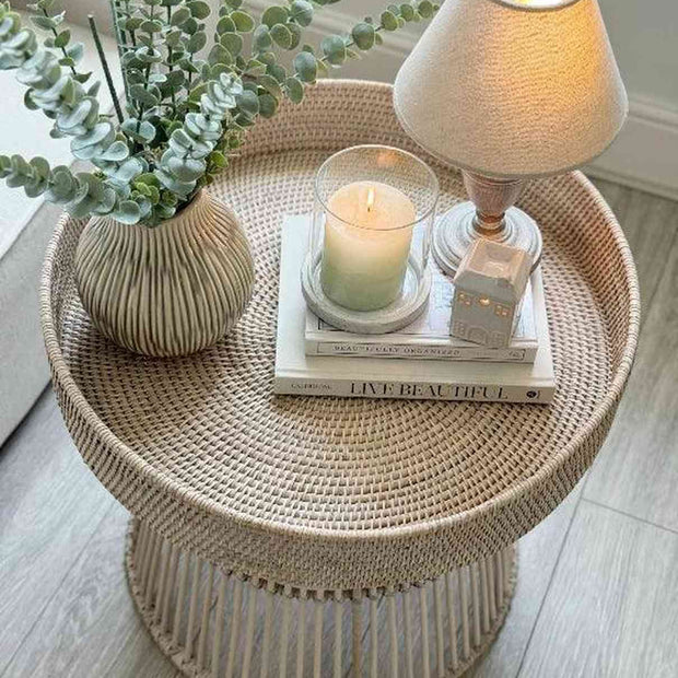 Lows rattan round side table with a natural woven surface and wooden legs, ideal for living room or bedroom decor.