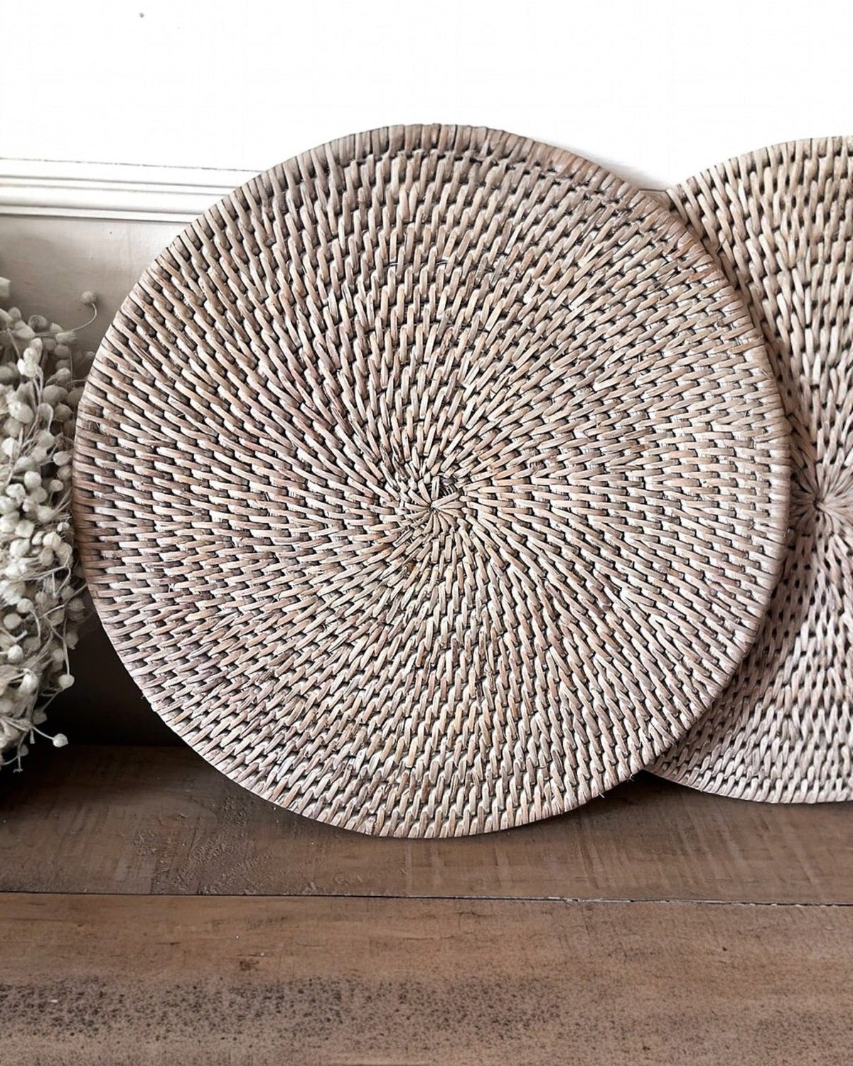 Set of two Lows rattan round placemats for home decor, showing woven natural rattan with a circular design.
