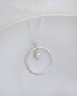 Sterling silver celestial hoop pendant necklace with a pearl, elegant jewelry piece by Lucy Kemp Jewellery.