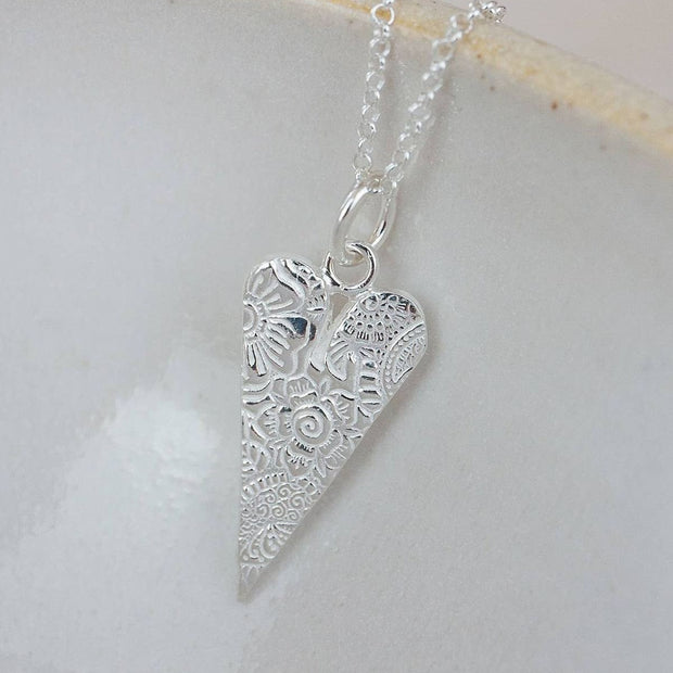 Sterling silver long heart charm pendant necklace by Lucy Kemp Jewellery, featuring a delicate heart-shaped pendant on a silver chain.