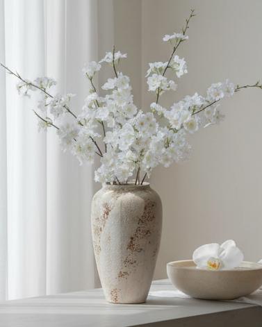 Artificial white blossom stem from Lulu Loves Home, showcasing delicate white flowers and green foliage for decorative arrangements.