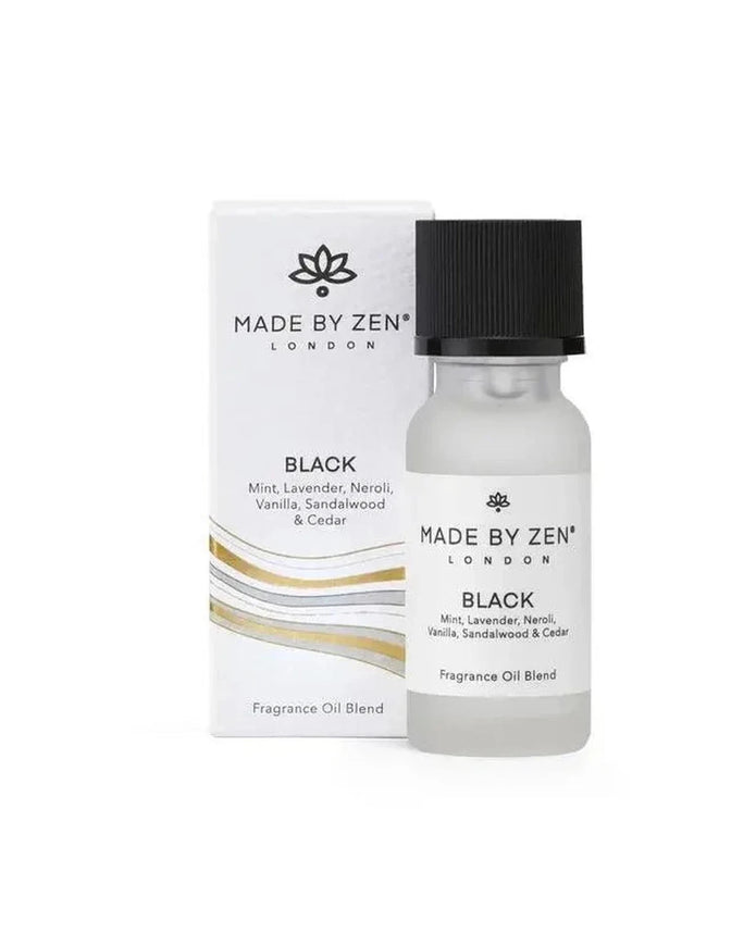 Made By Zen black diffuser and burner with signature scent fragrance oil for home aromatherapy, displayed on a wooden surface.