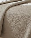 Malini Amity beige king size quilted bedspread on neatly made bed, showcasing soft furnishings and elegant bedding design.