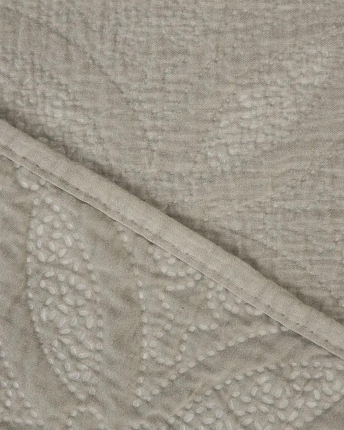 Malini Amity beige king size quilted bedspread with soft, textured fabric and elegant stitching on a neatly made bed.