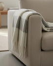 Malini Kalix grey blanket throw made of soft furnishings fabric, displaying a cozy, textured grey throw draped on a sofa.