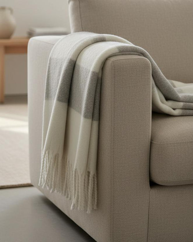 Malini Kalix grey blanket throw made of soft furnishings fabric, displaying a cozy, textured grey throw draped on a sofa.