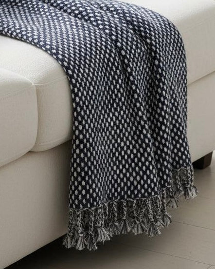 Navy blue Malini raindrop effect blanket throw laid flat, showcasing soft, cozy fabric with a distinctive raindrop pattern.