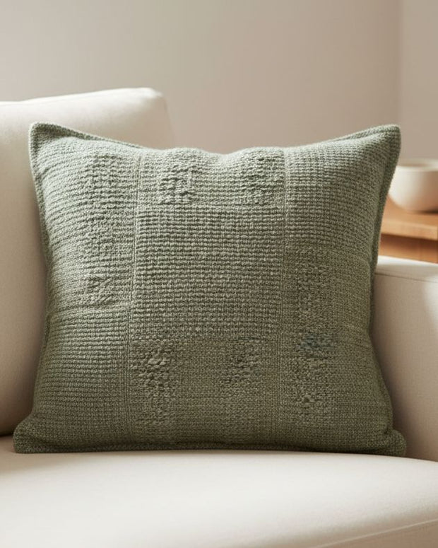 Olive green textured square cushion cover from Malini soft furnishings, showcasing fabric detail and modern design.