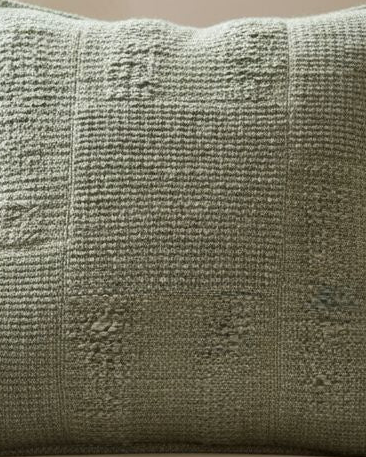 Olive green textured square cushion cover from Malini soft furnishings with a soft, woven fabric and subtle pattern.