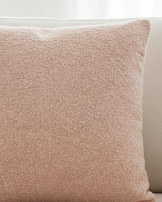 Pink textured cushion cover from Malini soft furnishings, showcasing a soft fabric with intricate surface detailing.