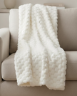 Ivory white Malini Sculpted Faux Bunny Rabbit Throw Blanket made of soft furnishings material, featuring a textured bunny design.