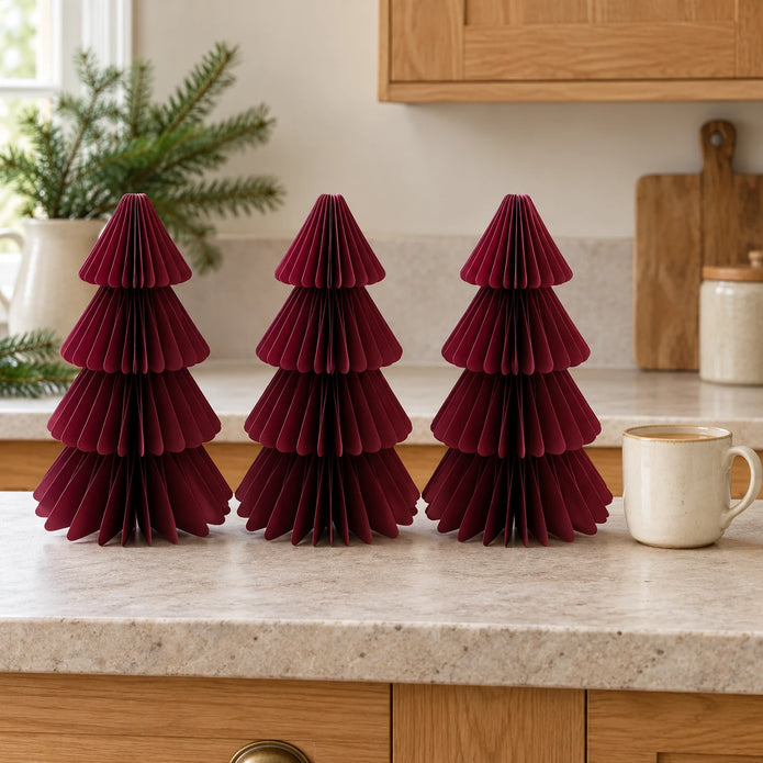 Set of three 25cm burgundy paper trees beside a mug of tea on a kitchen counter.