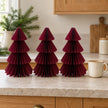 Set of three 25cm burgundy paper trees beside a mug of tea on a kitchen counter.