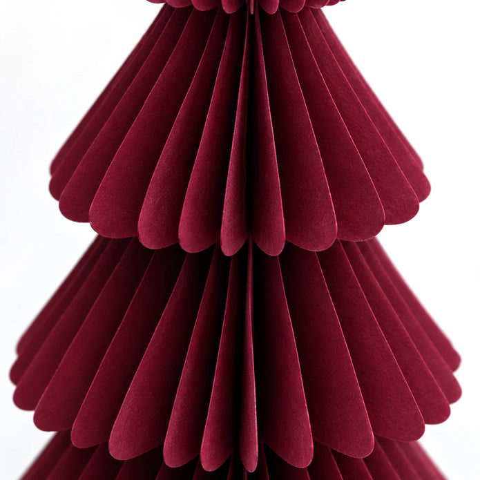 Close-up of burgundy paper folds and scalloped tier edges.
