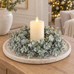 Frosted eucalyptus candle wreath styled around an ivory LED candle on a country-house console; accessories not included.
